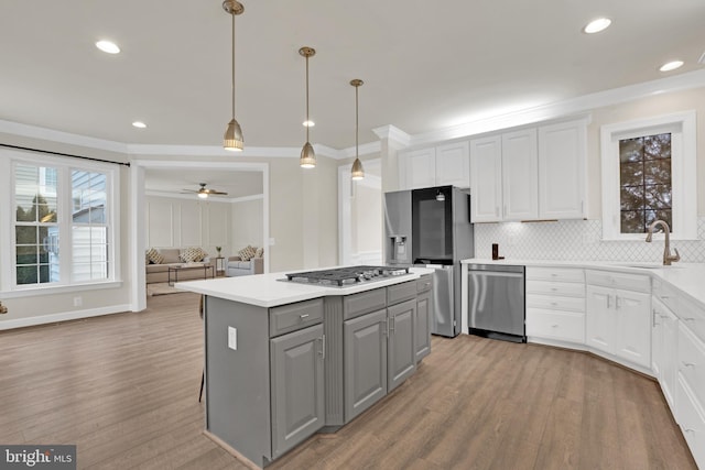 kitchen featuring stainless steel appliances, sink, white cabinetry, ceiling fan, and pendant lighting