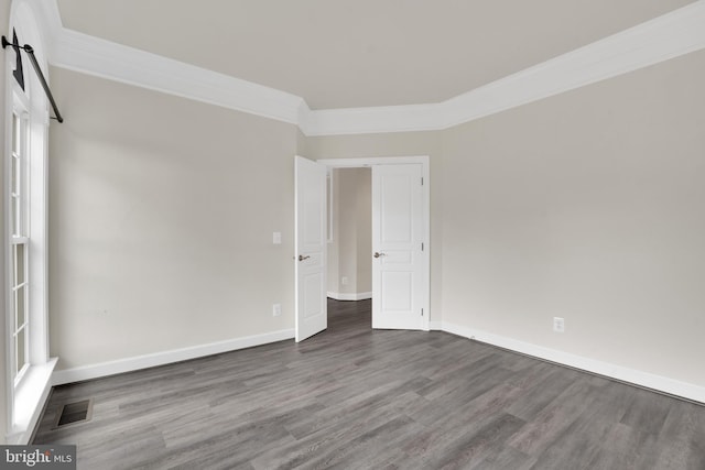 spare room featuring wood-type flooring and crown molding