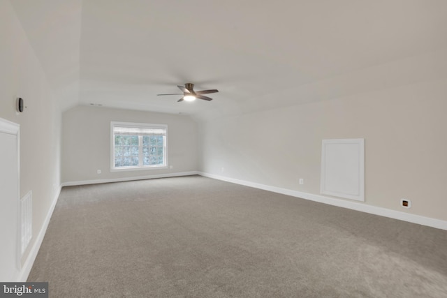 carpeted spare room featuring ceiling fan and vaulted ceiling