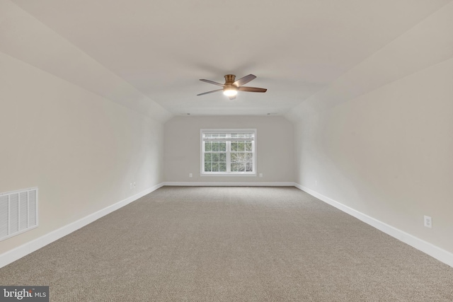 carpeted empty room with ceiling fan and lofted ceiling