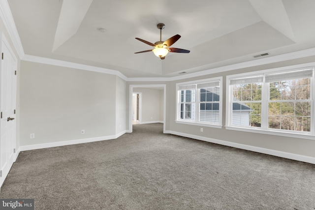 empty room featuring carpet flooring, ceiling fan, a tray ceiling, and ornamental molding