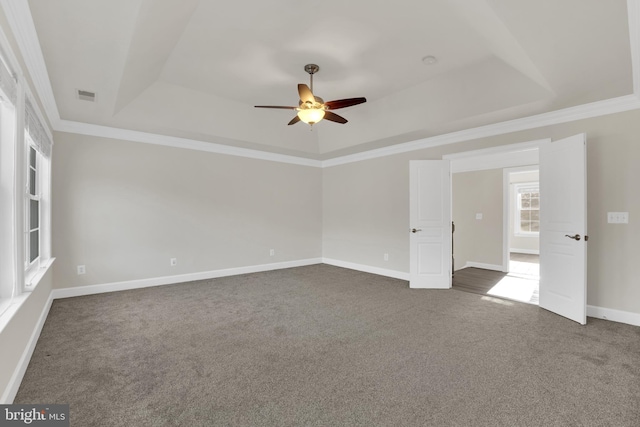 carpeted spare room with ceiling fan, crown molding, and a raised ceiling