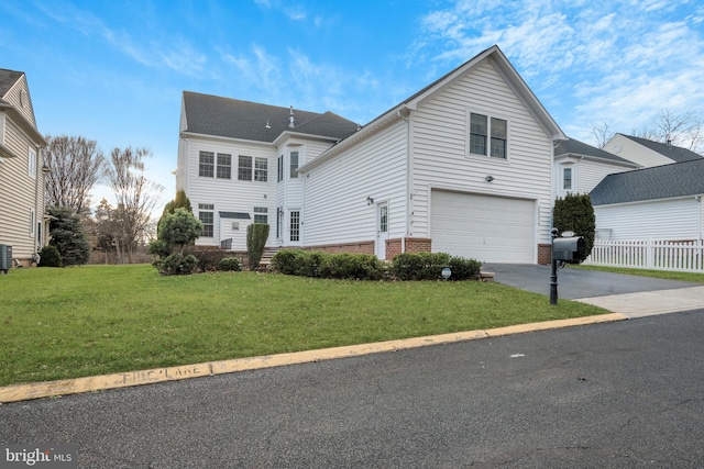 view of front of property with central air condition unit, a front yard, and a garage