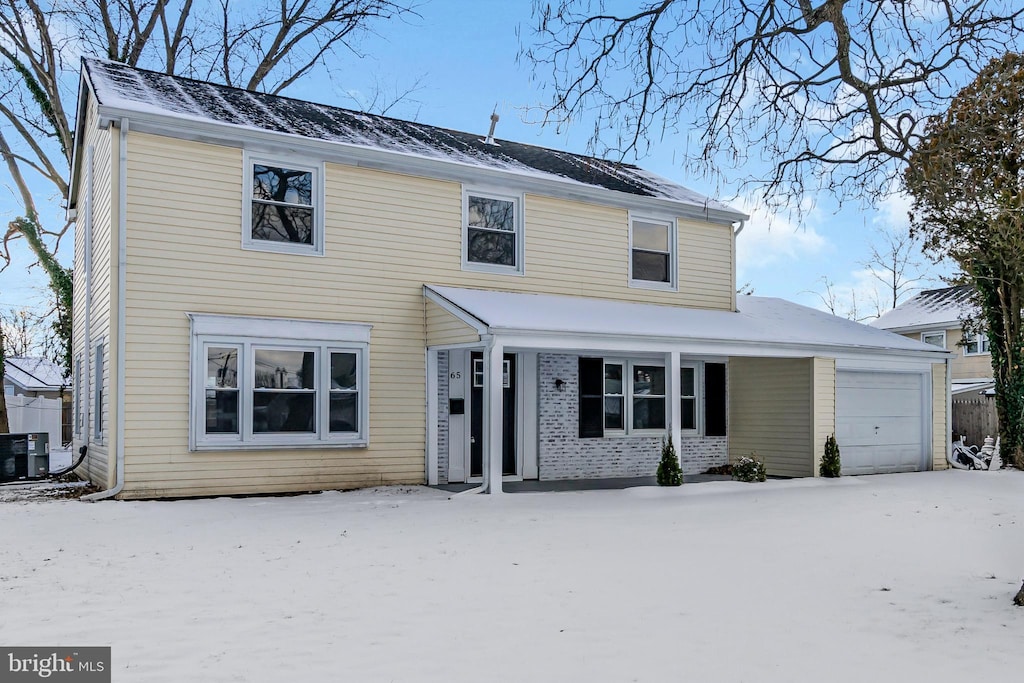 view of front of house featuring cooling unit, a porch, and a garage