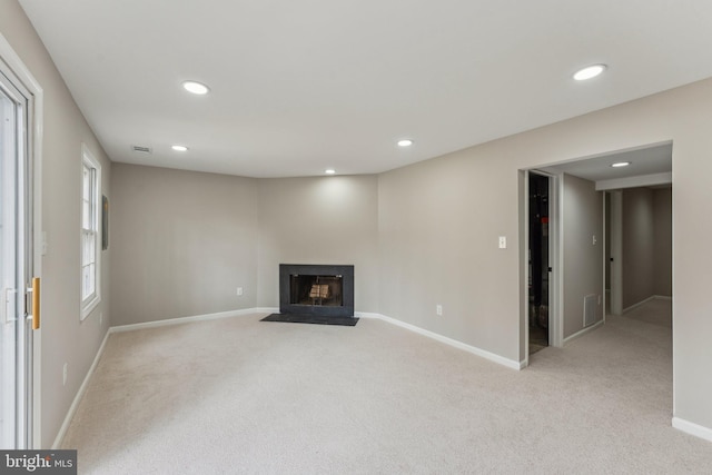 unfurnished living room featuring light carpet