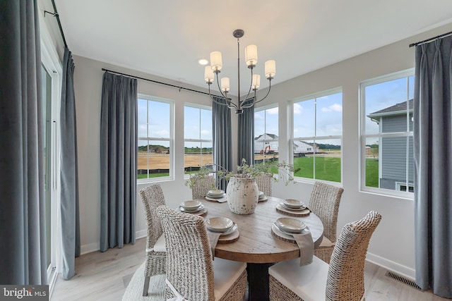 dining space featuring light hardwood / wood-style floors and a chandelier