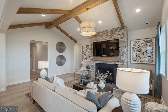 living room featuring a fireplace, light hardwood / wood-style flooring, wood ceiling, and vaulted ceiling with beams