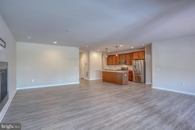 unfurnished living room with sink and light hardwood / wood-style flooring