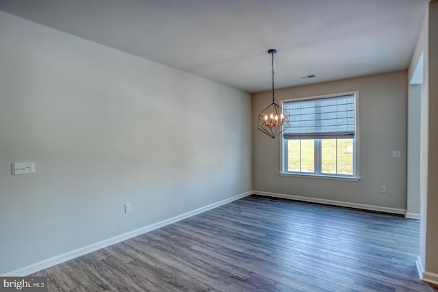 unfurnished room with dark hardwood / wood-style flooring and a notable chandelier