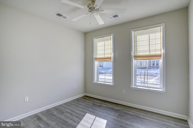 spare room featuring ceiling fan, a wealth of natural light, and light hardwood / wood-style flooring