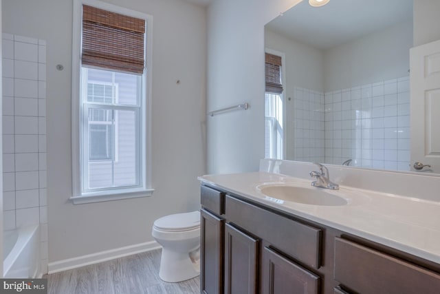 full bathroom featuring toilet, vanity, wood-type flooring, and  shower combination