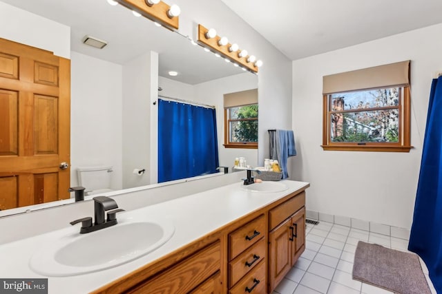 bathroom with vanity, tile patterned flooring, and toilet