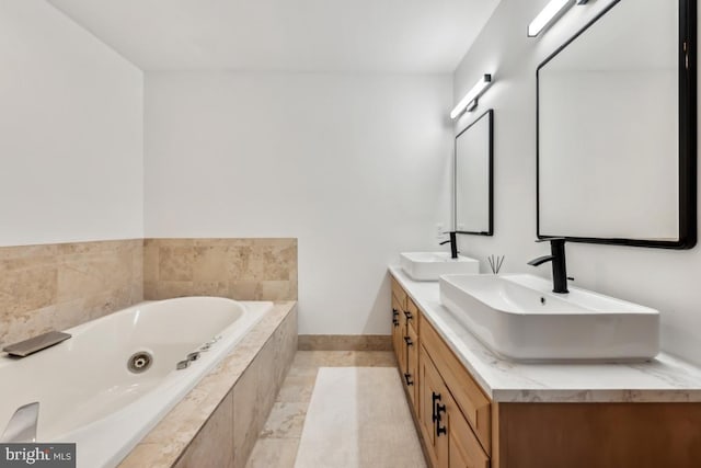 bathroom with a relaxing tiled tub, tile patterned floors, and vanity