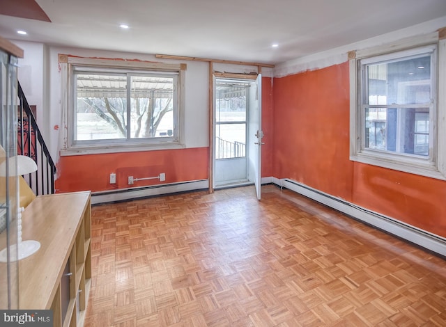 interior space with a baseboard heating unit and light parquet flooring