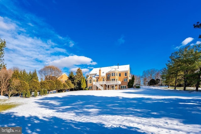 view of snow covered back of property