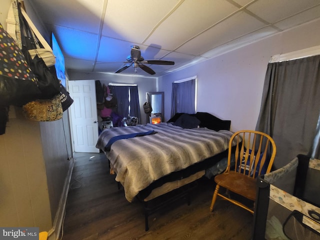 bedroom featuring dark wood-type flooring, ceiling fan, and a paneled ceiling