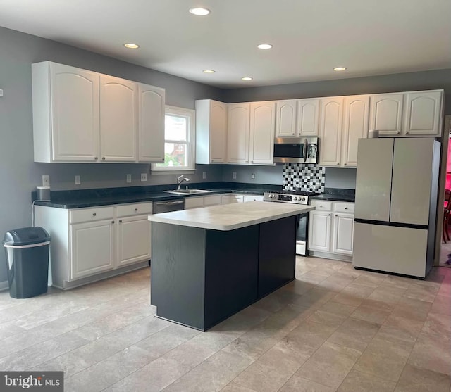 kitchen featuring white cabinets, a kitchen island, appliances with stainless steel finishes, and sink