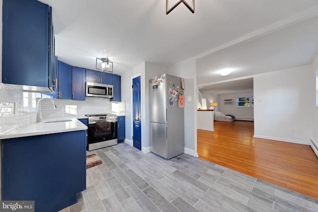 kitchen with light hardwood / wood-style flooring, stainless steel appliances, backsplash, blue cabinetry, and sink