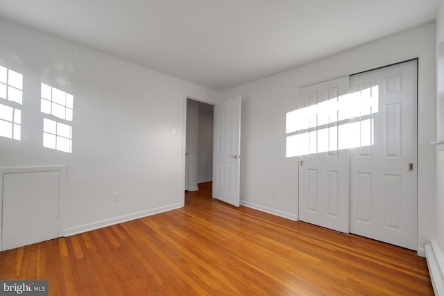 foyer entrance with a baseboard heating unit and light hardwood / wood-style floors