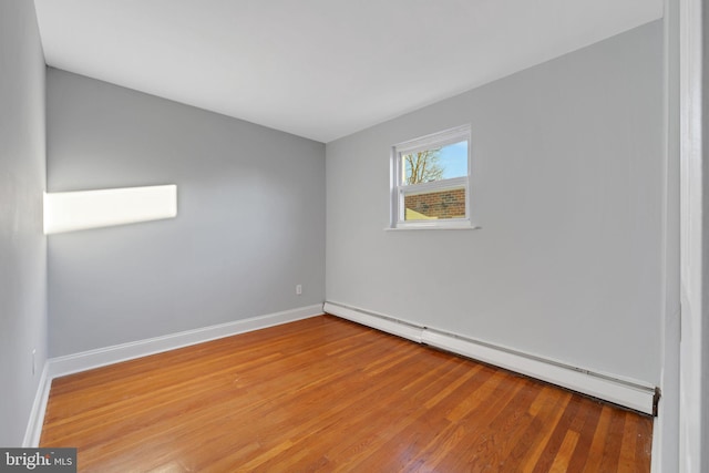 empty room featuring light wood-type flooring and a baseboard radiator