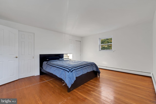 bedroom featuring a baseboard radiator and wood-type flooring