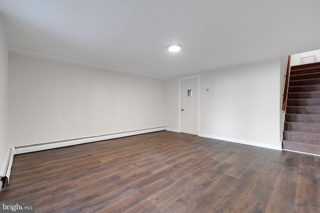 empty room with dark hardwood / wood-style floors and a baseboard heating unit