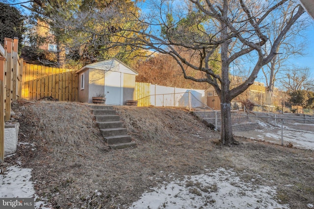 yard covered in snow with a storage unit