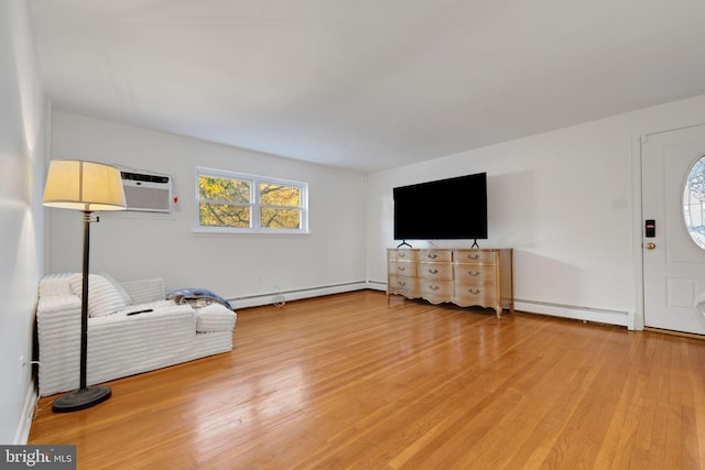 living room with baseboard heating, a wall mounted AC, and hardwood / wood-style flooring