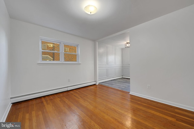 spare room with hardwood / wood-style floors and baseboard heating