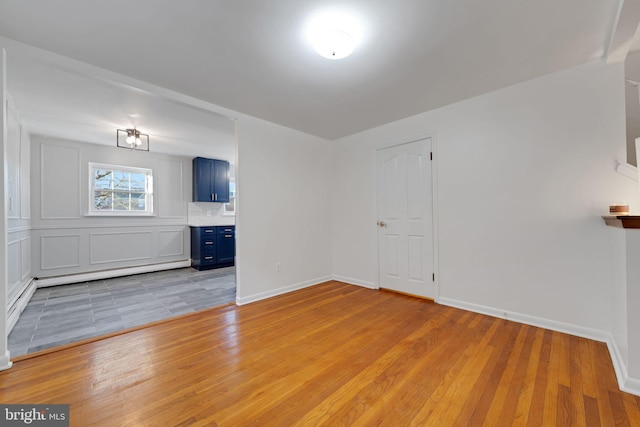 spare room featuring light hardwood / wood-style floors and a baseboard radiator