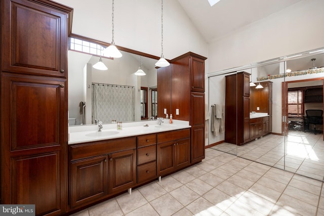 bathroom with tile patterned flooring, plenty of natural light, high vaulted ceiling, and vanity