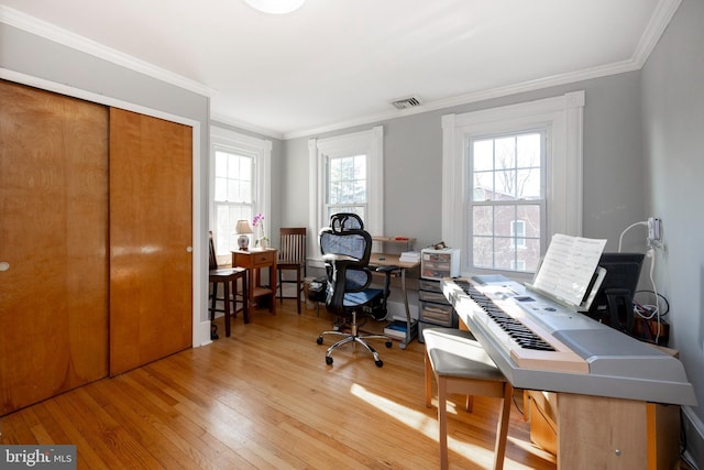 office featuring a healthy amount of sunlight, crown molding, and light hardwood / wood-style flooring