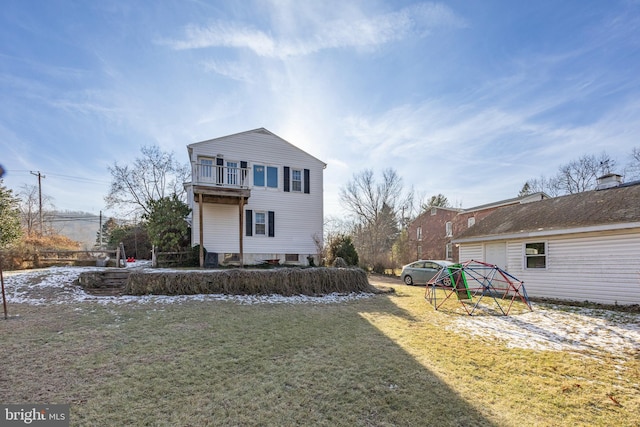 view of front of home featuring a balcony and a front yard