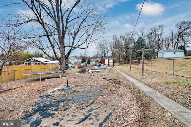 view of yard featuring a trampoline and a shed