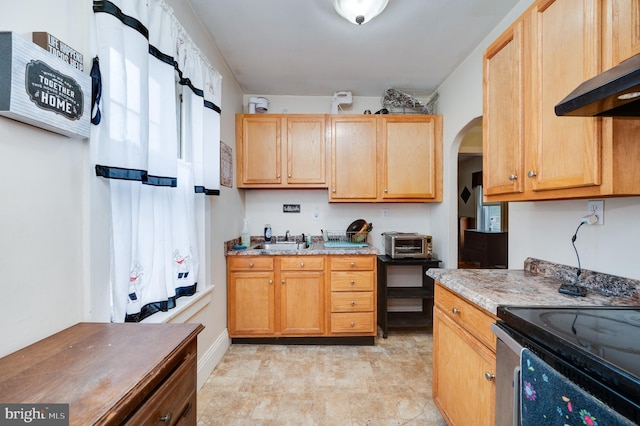 kitchen featuring light stone counters, sink, and wall chimney exhaust hood