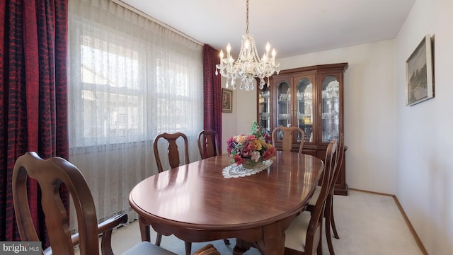 dining room with a chandelier and light carpet