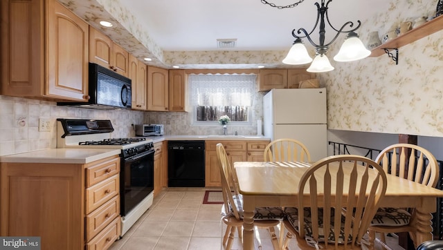 kitchen with decorative light fixtures, black appliances, tasteful backsplash, an inviting chandelier, and light tile patterned flooring