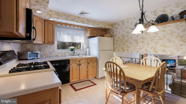 kitchen featuring decorative light fixtures, light tile patterned floors, black appliances, backsplash, and sink