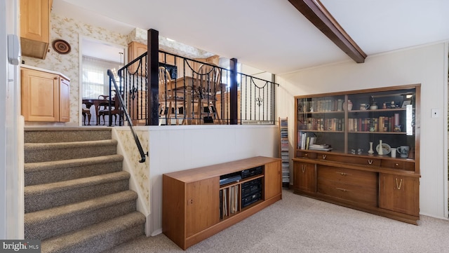 stairs featuring carpet and beamed ceiling