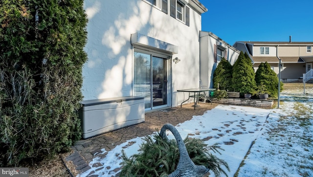 view of snow covered exterior with a patio