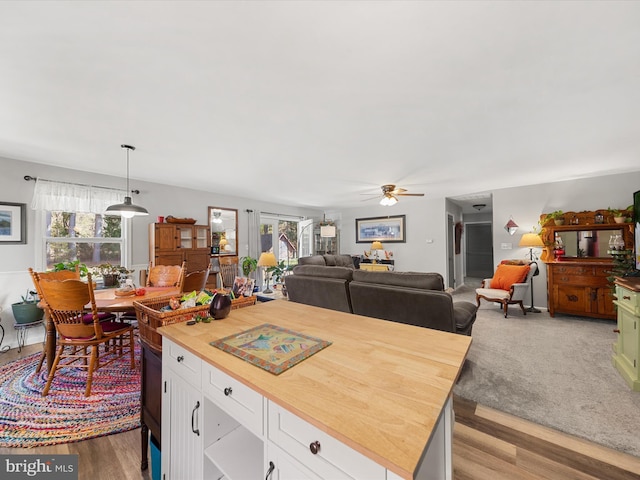 kitchen featuring decorative light fixtures, white cabinets, ceiling fan, and butcher block countertops