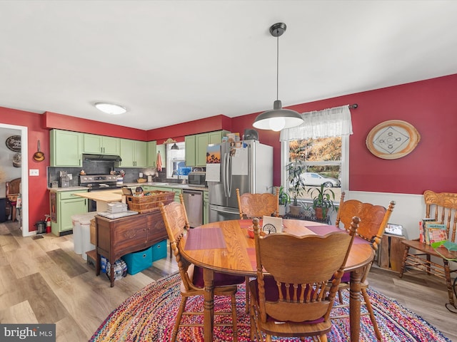 dining room with sink, light hardwood / wood-style floors, and plenty of natural light