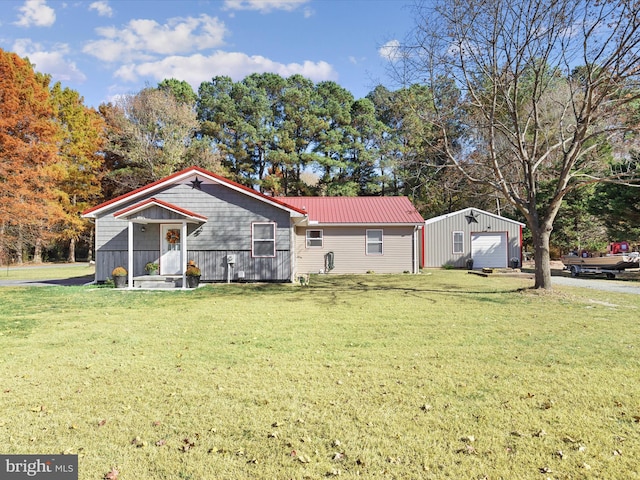 view of front of property featuring a front yard, a garage, and an outdoor structure