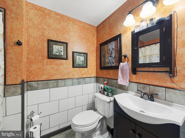 bathroom with toilet, vanity, and tile patterned floors