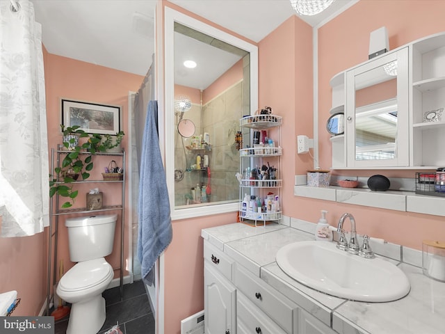 bathroom with toilet, vanity, tile patterned flooring, and walk in shower