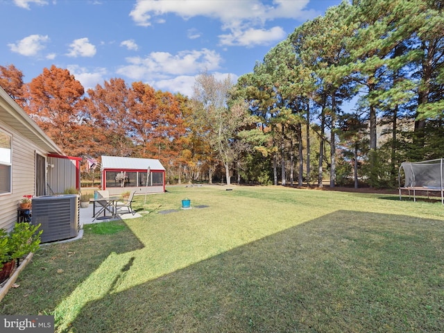 view of yard featuring central AC and a trampoline