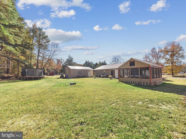 view of yard featuring a sunroom and a trampoline