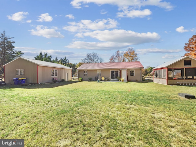 back of property with a lawn and a sunroom