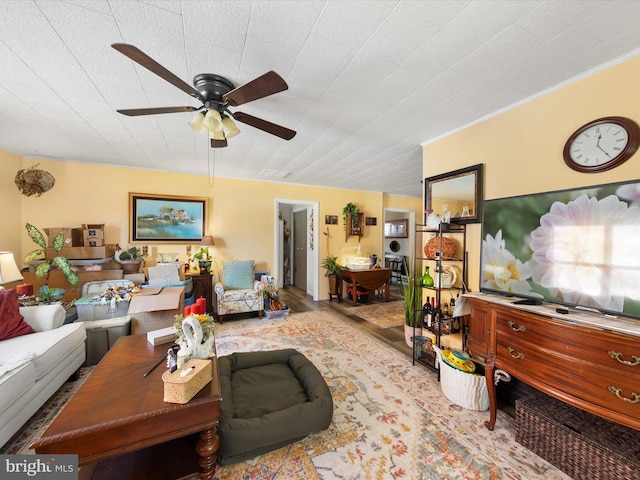 living room featuring ceiling fan and crown molding