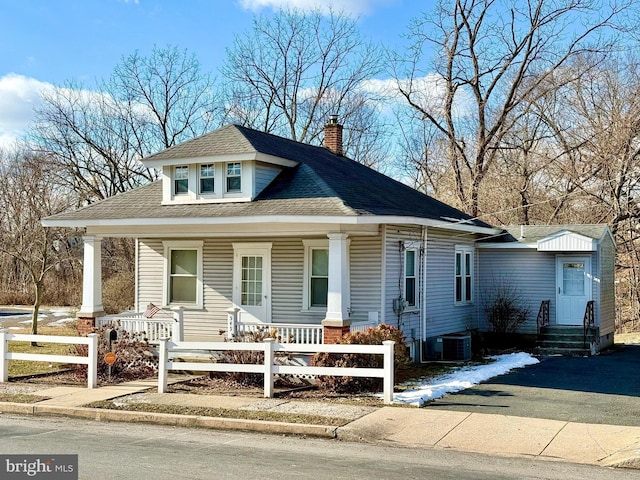 bungalow-style home with covered porch and cooling unit